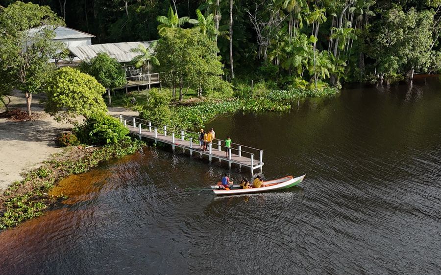 Adultos na beira do píer junto ao barco